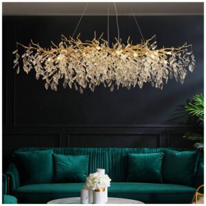 Opulent rectangular chandelier with golden branches and cascading crystal leaves illuminating a sophisticated dark-walled living space. The chandelier features intricate golden branches supporting numerous crystal leaf-shaped pendants, creating a stunning organic canopy. Warm light emanates from within, causing the crystal elements to sparkle brilliantly against the deep-colored background. Below, a plush emerald green velvet sofa anchors the room, complemented by a round marble coffee table adorned with a vase of white flowers. The dark walls, likely black or deep navy, feature subtle paneling, adding depth and texture to the space. A glimpse of a tropical plant is visible to the right, introducing a touch of natural greenery. This exquisite branch chandelier serves as a captivating focal point, blending natural inspiration with luxurious materials in a contemporary setting, perfect for creating an atmosphere of refined elegance and drama.