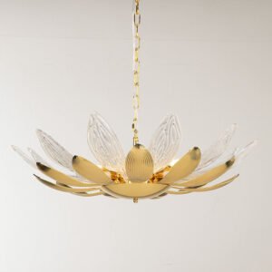 A elegant chandelier designed to resemble a blooming lotus flower, suspended against a light background. The fixture features alternating gold and crystal petals radiating outward from a central golden core. The gold petals have a smooth, ribbed surface with a warm metallic sheen, while the crystal petals are clear and intricately textured with a pattern reminiscent of delicate leaf veins. The crystal elements are transparent and catch light beautifully, creating a subtle sparkling effect. At the center, a golden orb forms the flower's core, from which the petals unfurl. The chandelier's base is a curved gold dish that supports the entire structure. Warm light emanates from within the chandelier, softly illuminating the petals. The piece is suspended by a delicate golden chain, adding to its refined appearance. This chandelier masterfully combines organic, lotus-inspired forms with luxurious materials, resulting in a striking blend of nature-inspired design and high-end aesthetics. It appears both delicate and substantial, promising to be a captivating focal point in any interior space.