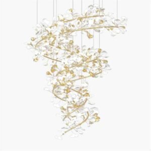 An elegant spiral chandelier featuring delicate white glass petals and gold-toned branches against a white background. The chandelier has an organic, tree-like structure that twists downward in a graceful helix. Numerous white glass elements, resembling stylized flowers or leaves, are attached to the golden metallic framework, creating a cascading effect. The fixture is suspended by thin wires, giving it a floating appearance. The interplay between the translucent white glass and the shimmering gold accents creates a soft, ethereal glow. The chandelier's intricate design combines natural, botanical-inspired forms with luxurious materials, resulting in a stunning piece that bridges the gap between functional lighting and sculptural art. The white-on-white presentation emphasizes the chandelier's delicate structure and intricate details.