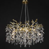 Luxurious chandelier featuring golden branches adorned with a multitude of crystal pendants, suspended against a black background. The fixture hangs from a circular gold ceiling plate with an intricate textured design, supported by thin wires. The main body consists of ornate golden branches forming a tree-like structure, from which hundreds of crystal pendants of various shapes and sizes cascade downward. Warm light emanates from within, causing the crystal elements to sparkle brilliantly, creating a striking contrast against the dark backdrop. This stunning branch chandelier combines organic forms with opulent materials, evoking the image of a magical, glowing tree canopy. The interplay of gold and crystal against the black background enhances the chandelier's dramatic and ethereal beauty, making it a perfect focal point for upscale interiors.