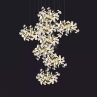 Stunning branch chandelier featuring multiple clusters of illuminated floral elements. Delicate white petals and golden stems create a cascading effect against a dark background. This exquisite branch chandelier showcases a series of interconnected floral bursts, each suspended by thin wires, giving the illusion of floating blossoms. The intricate design mimics the organic beauty of blooming branches, with warm light emanating from within each flower cluster. The chandelier's unique arrangement adds depth and visual interest, perfect for creating a captivating focal point in modern, luxury interiors.