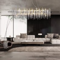 A sophisticated living room featuring a stunning rectangular chandelier with crystal icicle-like pendants and gold accents. The chandelier hangs prominently above a spacious light gray sectional sofa. The room has a monochromatic color scheme with a black accent wall, vertical blinds, and a textured rug. A large rectangular coffee table sits in front of the sofa. Modern decor elements include a tall black floor lamp, a cylindrical side table, and a unique curved lounger. The space combines elegance with contemporary design, showcasing a balance of textures and minimalist furniture against the dramatic lighting fixture.