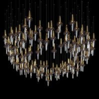 A striking large hotel chandelier showcasing innovative custom lighting design. This big chandelier features a multitude of suspended glass elements resembling elongated teardrops or icicles, each topped with a golden conical cap. The clear glass drops and gold accents create a harmonious contrast against the dark background. Arranged in a gentle arc formation, the chandelier's shape suggests a wave or a crescent moon. The varying lengths of the glass elements add depth and dimension, while thin wires supporting each piece are barely visible, enhancing the floating effect. This exquisite piece exemplifies sophisticated custom lighting, perfect for creating a dramatic focal point in luxurious hotel spaces.